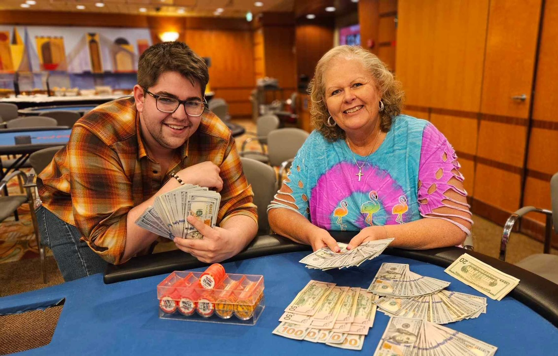 2024 April Main Event - Kyle and Patty sitting at the poker table with their winnings.